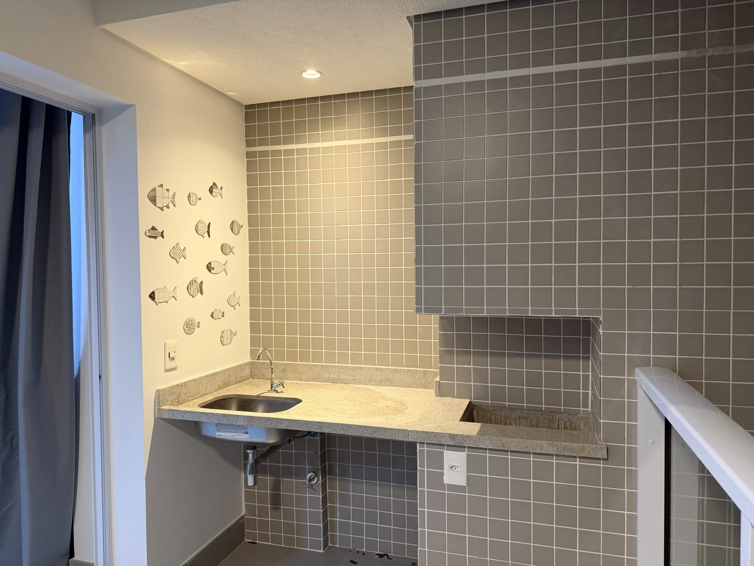 Varanda gourmet com churrasqueira do apartamento em São Lourenço