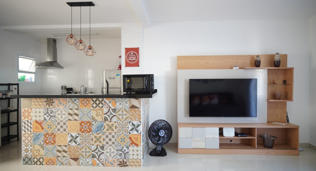 Vista interna integrada conectando a sala de estar climatizada com a cozinha americana moderna em casa de praia em Juquehy.