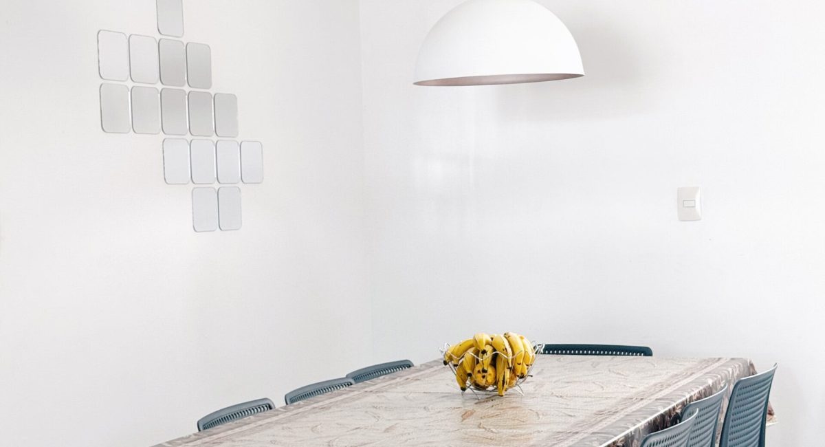 Mesa de jantar de madeira para 6 pessoas com cadeiras azuis modernas e ar-condicionado split em casa de temporada em Juquehy.